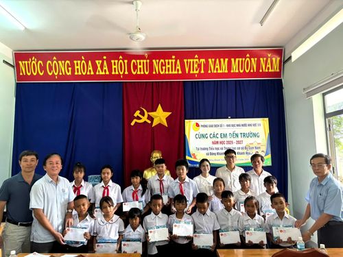 Đại diện Phòng Giao dịch số 1 và Ban Giám hiệu nhà trường trao quà cho các học sinh.