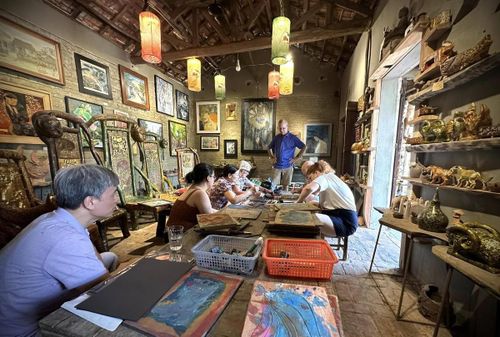 Du khách quốc tế trải nghiệm tại cơ sở của nghệ nhân ưu tú Nguyễn Tấn Phát ở làng cổ Đường Lâm. Ảnh: NVCC.