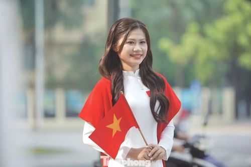 Nhiều bạn nữ tạo dáng trong tà áo dài trắng cùng sắc cờ đỏ sao vàng giữa Quảng trường Ba Đình. Ảnh: Duy Phạm
