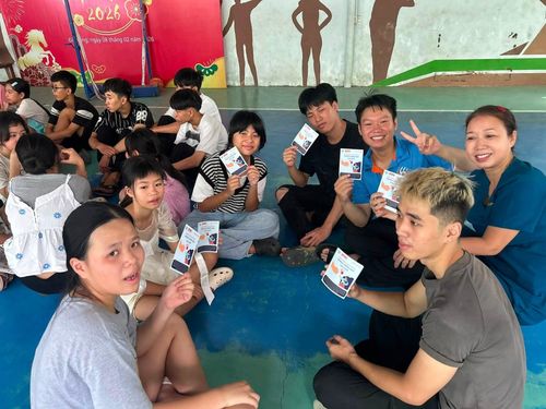 Các bạn nhỏ cầm trên tay tài liệu về phòng chống bạo lực giới, bệnh lây truyền qua đường tình dục và các biện pháp KHHGĐ