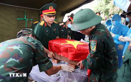 Trang trọng thực hiện quy trình khai quật, đưa hài cốt liệt sĩ chưa xác định danh tính về khu vực lấy mẫu sinh phẩm liệt sỹ tại Nghĩa trang Liệt sỹ Ngọc Hồi (xã Thanh Trì). (Ảnh: Văn Điệp/TTXVN)