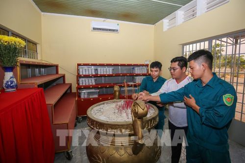 Cán bộ, chiến sĩ thắp nén nhang tưởng nhớ, tri ân các Anh hùng liệt sĩ sau khi hoàn thành việc bàn giao mẫu tại nhà lưu mẫu. Ảnh: Giang Phương - TTXVN
