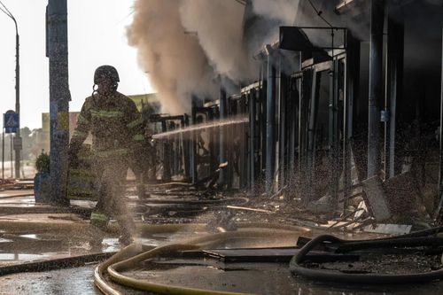 Lực lượng cứu hỏa nỗ lực dập lửa tại một khu chợ sách ở Kiev, Ukraine, ngày 16/8/2026, sau cuộc tập kích qua đêm của Nga bằng tên lửa đạn đạo và UAV động cơ phản lực. Ảnh: Getty Images.