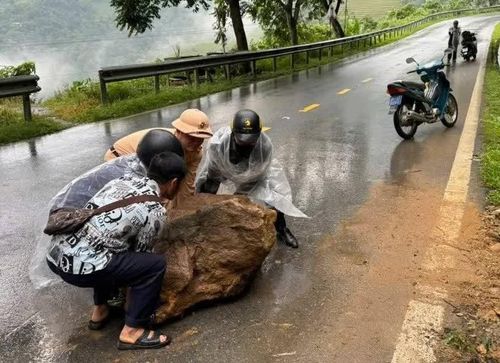 Chiến sĩ cảnh sát giao thông cùng người dân dọn đá lăn ra đường, giải phóng vật cản trở, đảm bảo an toàn giao thông.