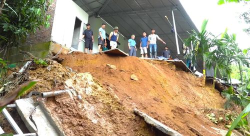 Một góc sân, mái che, tường rào và nhà vệ sinh phía ngoài của gia đình chị Nhàn bị sạt sau mưa lũ.
