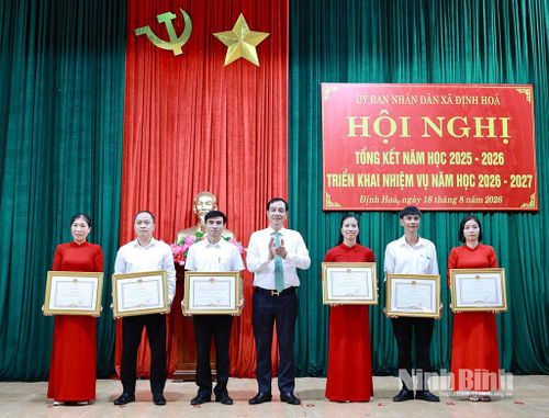 Thừa ủy quyền, lãnh đạo xã Định Hoá trao danh hiệu “Tập thể lao động xuất sắc”; Bằng khen của Chủ tịch UBND tỉnh cho các tập thể, cá nhân có thành tích xuất sắc trong năm học 2025-2026. Ảnh: Lan Anh