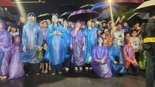 Cơn mưa nặng hạt kéo dài hơn 1 tiếng đồng hồ vẫn không cản được bước chân những người dân xứ Nghệ. Hàng nghìn người đã đứng dọc 2 bên đường Trường Thi và khu vực Quảng trường Hồ Chí Minh để chờ đợi sự kiện.