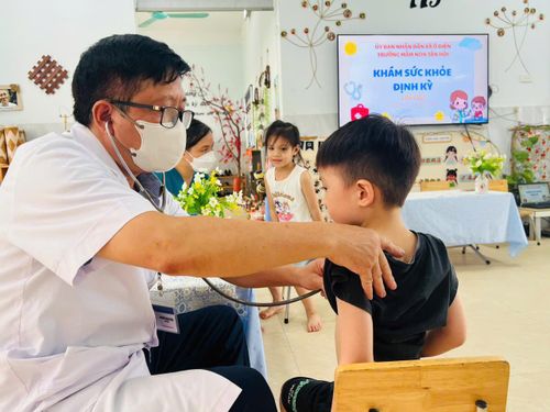 Cán bộ y tế khám, kiểm tra sức khỏe cho trẻ tại Trường Mầm non Tân Hội. Ảnh: Đỗ Duẩn