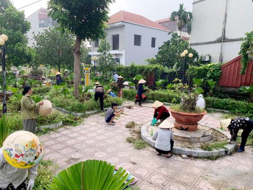 Người dân xã Đan Phượng tham gia cắt tỉa cây xanh, làm đẹp vườn hoa. Ảnh: ĐP