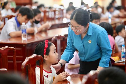 Phó Chủ tịch Liên đoàn Lao động TPHCM Nguyễn Kim Loan trò chuyện với các em học sinh là con công nhân nhận học bổng Nguyễn Đức Cảnh, ngày 7-3-2026. ẢNH: LINH LINH
