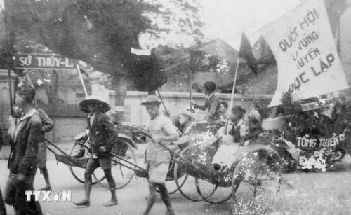 Thông qua các đoàn thể cứu quốc, Mặt trận Việt Minh đã tuyên truyền, vận động quần chúng tự nguyện và hăng hái tham gia các phong trào sản xuất, cứu đói, hũ gạo tiết kiệm, tuần lễ vàng, bình dân học vụ... nhằm phát huy tinh thần yêu nước của Nhân dân để vượt qua những khó khăn về kinh tế, tài chính. Trong ảnh: Nhân dân lao động Thủ đô cổ động cho ngày Tổng tuyển cử đầu tiên. (Ảnh: TTXVN)