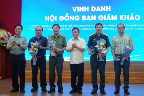 Ban Tổ chức tặng hoa tri ân Hội đồng Ban giám khảo cuộc thi. (Ảnh: PV/Vietnam+)