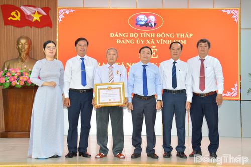 Lãnh đạo tỉnh Đồng Tháp và lãnh đạo xã Vĩnh Kim chụp ảnh lưu niệm tại lễ trao Huy hiệu 70 năm tuổi Đảng cho đồng chí Đoàn Hiếu Thảo.