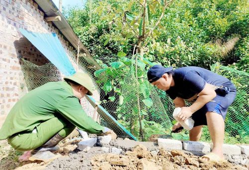 Cán bộ Công an xã Nghĩa Tá giúp người dân địa phương xóa nhà tạm, nhà dột nát.