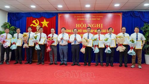 Đồng chí Nguyễn Minh Luân (thứ 6 từ phải sang), Phó Chủ tịch UBND tỉnh và Giám đốc Sở GD&ĐT Nguyễn Văn Nguyên (thứ 6 từ trái sang), trao quyết định sáp nhập các cơ sở giáo dục.