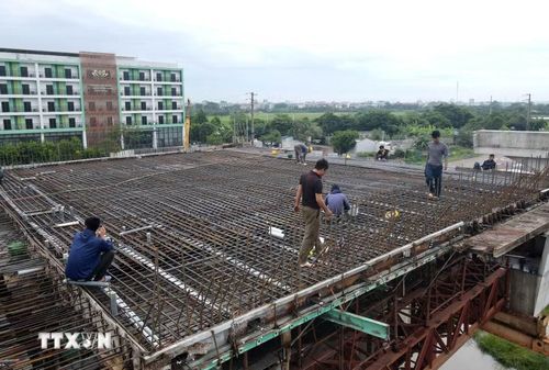 Công nhân lắp đặt cốt thép bản mặt cầu thuộc cầu vượt đường Vành đai 4 qua Quốc lộ 1A. (Ảnh: Vũ Quang/TTXVN)