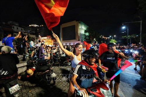 Du khách nước ngoài hòa cùng niềm vui chiến thắng của đội tuyển Việt Nam. Ảnh: Phạm Tuấn Anh/TTXVN