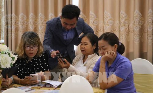 Hướng dẫn học viên thực hành trên điện thoại. Ảnh: Nguyễn Hằng - TTXVN