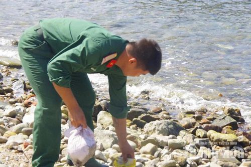 Cán bộ, chiến sĩ thu gom rác theo sóng dạt vào bờ, giữ sạch khu vực ven đảo.