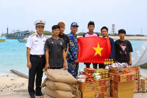 Cán bộ, chiến sĩ đảo Song Tử Tây tặng cờ Tổ quốc và nhu yếu phẩm cho ngư dân.