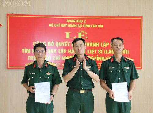 Anh Trường (bên phải) nhận Quyết định thành lập Đội tìm kiếm, quy tập hài cốt liệt sĩ (lâm thời).