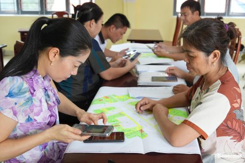 Cán bộ xã Nam Phù đối soát, quét và cập nhật thông tin dữ liệu đất đai của người dân lên phần mềm dữ liệu. Ảnh: Khánh Huy