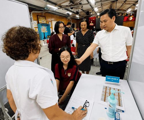 Phó Chủ tịch UBND phường Nghĩa Đô Lê Mạnh Tiến hỏi thăm, động viên các cháu học sinh. Ảnh: HY