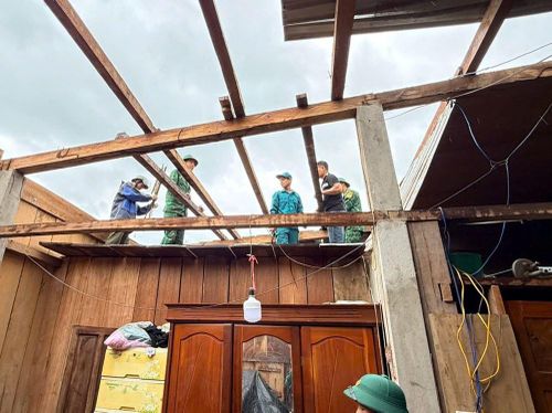 Bộ đội cùng chính quyền địa phương giúp dân lợp lại mái nhà