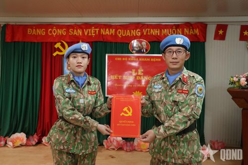 Thiếu tá Nguyễn Đức Trọng, Bí thư Chi bộ, Chủ nhiệm Khoa Khám bệnh trao Quyết định kết nạp đảng viên cho Đại úy QNCN Đặng Thị Thanh Phượng.