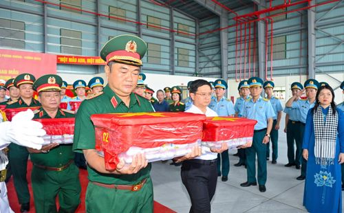  Trung tướng Lê Xuân Thế, Tư lệnh Quân khu 7 và Phó Chủ tịch UBND TPHCM Nguyễn Mạnh Cường cùng các đại biểu thực hiện nghi thức đưa mẫu hài cốt liệt sĩ lên máy bay. Ảnh: MẠNH THẮNG 