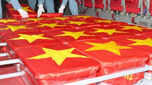  Cán bộ, chiến sĩ trang trọng đặt các mẫu hài cốt liệt sĩ lên máy bay. Ảnh: MẠNH THẮNG 