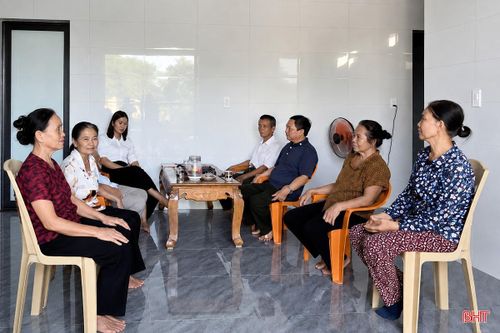 Bà Trần Thị Lý (ngoài cùng bên trái) trò chuyện cùng bà con láng giềng trong ngôi nhà mới.