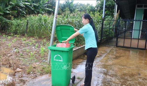 Chị Lê Thị Ngọc Diệp, người dân thôn Thống Nhất, xã Đak Nhau, thực hiện bỏ rác đúng nơi quy định, góp phần giữ gìn vệ sinh môi trường khu dân cư.