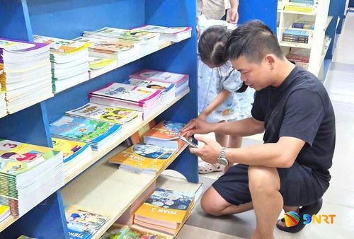 Phụ huynh tìm sách giáo khoa tại một nhà sách trên đường Bạch Đằng.