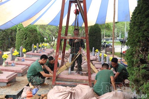 Lực lượng chức năng áp dụng sáng kiến Ba lăng xích vào việc nâng nắp mộ, giảm nhân lực, tạo thuận lợi cho việc lấy mẫu và hoàn nguyên phần mộ.
