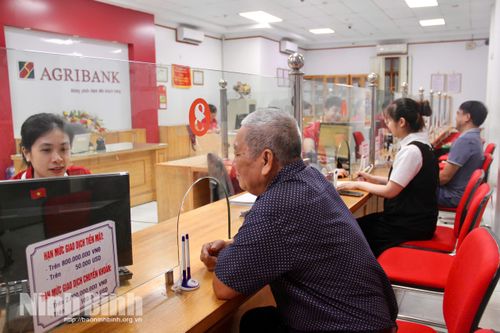 Cán bộ Agribank Chi nhánh Nho Quan Ninh Bình hướng dẫn người dân làm thủ tục tại quầy.