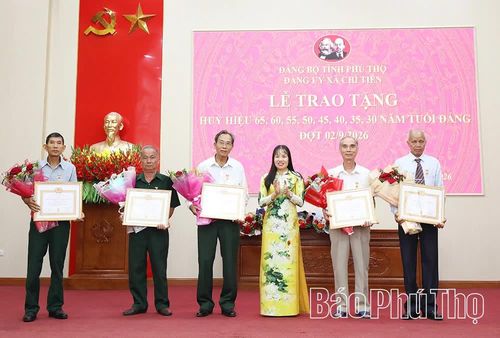 Bí thư Đảng ủy xã Nguyễn Thị Thảo Nam trao tặng Huy hiệu 55 năm tuổi Đảng cho các đảng viên.