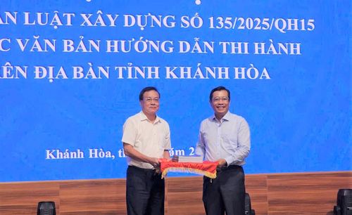 Ông Đàm Đức Biên, Phó cục trưởng Cục Kinh tế - Quản lý đầu tư xây dựng trao tài liệu tập huấn cho ông Nguyễn Thành Phú, Giám đốc Sở Xây dựng tỉnh Khánh Hòa.