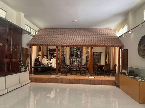 Mô hình nhà ba gian cùng các vật dụng sinh hoạt tái hiện không gian sống mộc mạc của cư dân Nam Bộ xưa. Ảnh: Tường Quang