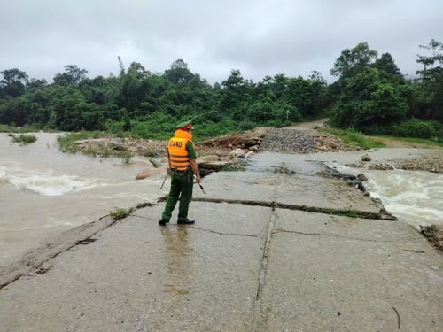 Công an xã Hướng Phùng kiểm tra, cảnh giới tại một cầu tràn bị nước lũ chia cắt, kịp thời cảnh báo người dân không đi vào khu vực nguy hiểm.