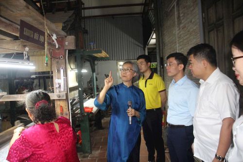 Các đại biểu thăm làng nghề Vạn Phúc, nghe các nghệ nhân giới thiệu về nghề dệt... Ảnh: Kim Huệ