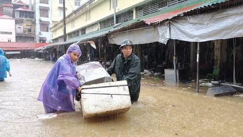 Lực lượng bộ đội hỗ trợ người dân di chuyển vật dụng trong mưa bão. (Ảnh : QSLS)