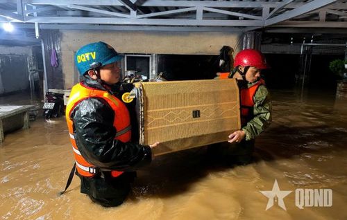 Cán bộ, chiến sĩ Ban CHQS phường 3 Bảo Lộc (Bộ CHQS tỉnh Lâm Đồng) hỗ trợ người dân ở khu vực bị ngập sâu di chuyển tài sản trong đêm 27-7-2026.
