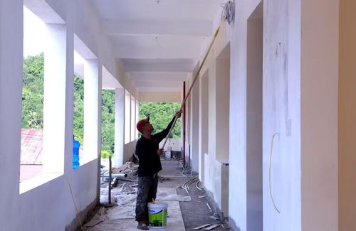 Công nhân sơn tường hành lang khu lớp học Trường Nội trú liên cấp Yên Khương.
