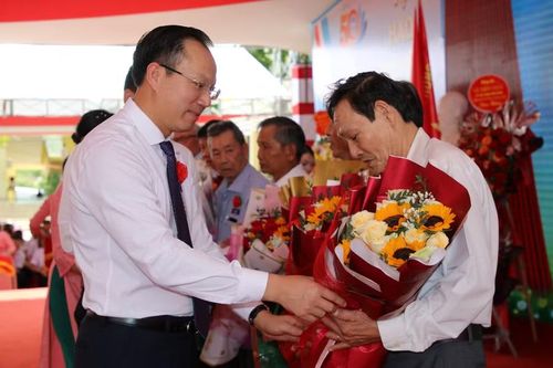 Lãnh đạo Bộ GD&ĐT, UBND tỉnh tặng hoa tri ân thầy cô qua các thời kỳ. (Ảnh: Thế Hùng)
