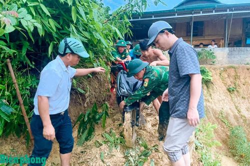 Cán bộ, chiến sĩ Đồn Biên phòng Yên Khương cùng các lực lượng hỗ trợ di dời tài sản của 2 hộ gia đình có nguy cơ sạt lở đến nơi an toàn. Ảnh: Biên Cương