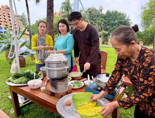 Du khách đến Làng Văn hóa được xem bà con đến từ Cần Thơ trình diễn làm món bánh xèo. Ảnh: BTC