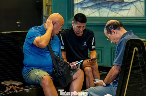 Số khách ít ỏi đang ngồi chờ trong cảng thì liên tục cập nhật thông tin ảnh hưởng của bão số 4 để có kế hoạch di chuyển phù hợp.