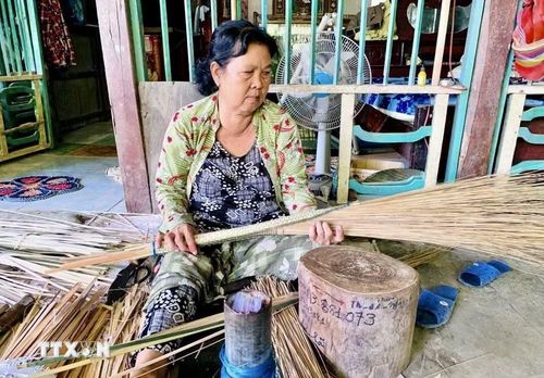 Người dân ấp Đông An, xã Phú Hòa, tỉnh An Giang tận dụng sân nhà, mái hiên để làm chổi cọng dừa. (Ảnh: Thanh Sang/TTXVN)