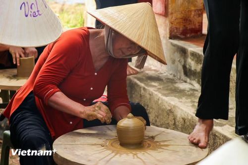 Nghệ nhân nhịp nhàng tạo hình gốm trên bàn xoay truyền thống được điều khiển hoàn toàn bằng sức đẩy của đôi bàn chân. (Ảnh: Thanh Phong/Vietnam+)